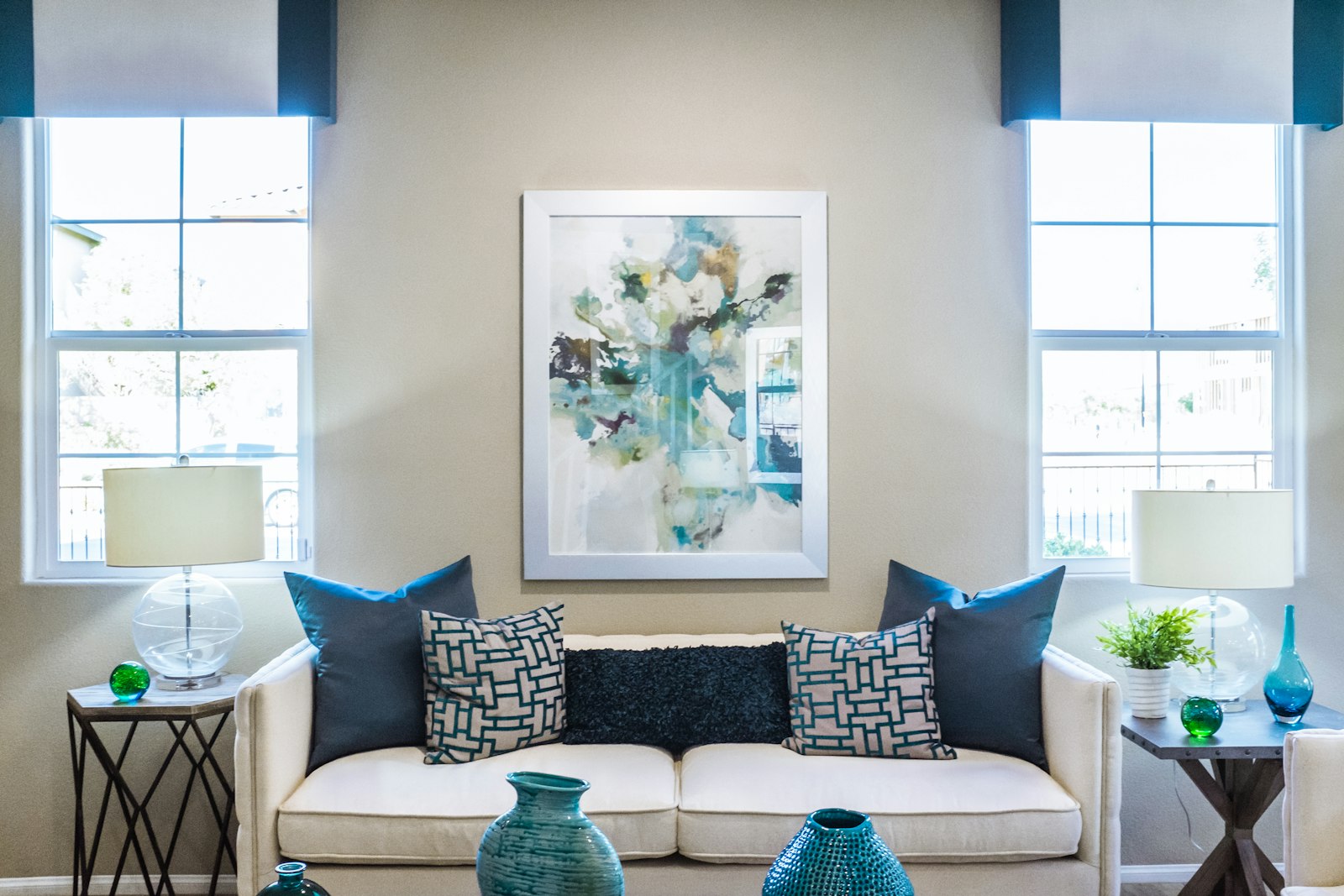 Living room with a cream sofa, framed artwork and lamps either side